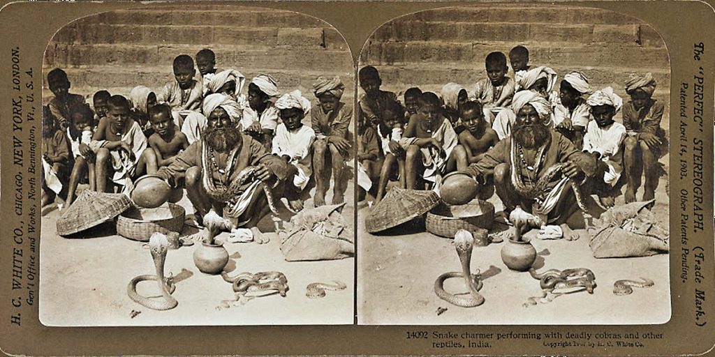 Indian Snake Charmer with Cobras Coming Out of Pots and Wicker Baskets While Children Look On