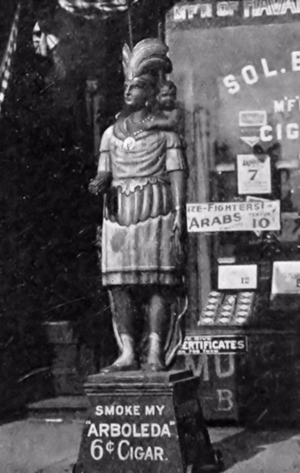 This statue is carrying a baby on his back and entreats you to "Smoke My Arboleda" for only 6 cents.